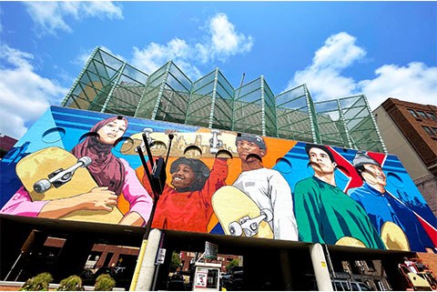 colorido mural de diversos niños sosteniendo patinetas